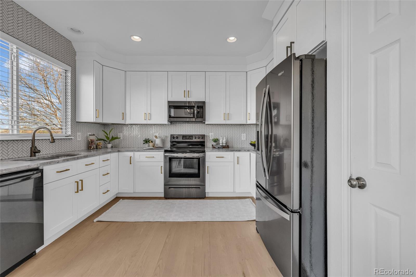 8204 Swadley Street Arvada, CO 80005 - Photo 13 of 39 a kitchen with cabinets and stainless steel appliances