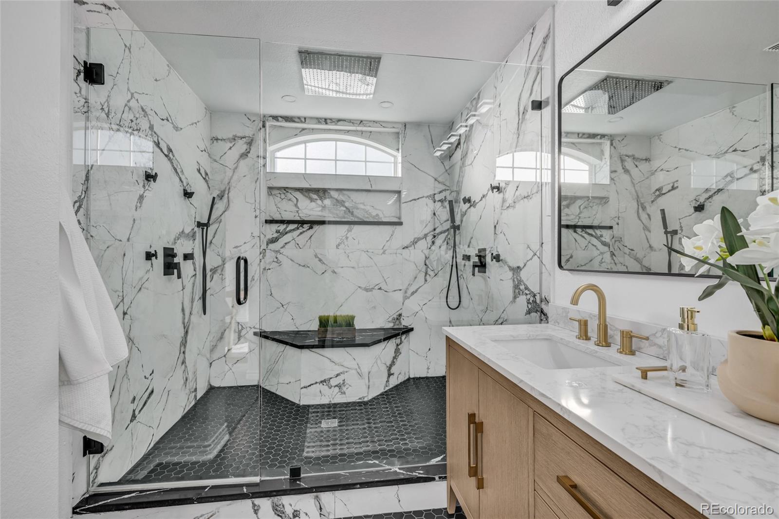 8204 Swadley Street Arvada, CO 80005 - Photo 19 of 39 a bathroom with a granite countertop sink a mirror and shower