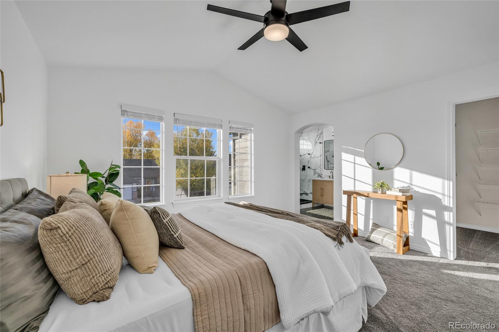 8204 Swadley Street Arvada, CO 80005 - Photo 21 of 39 a bedroom with a bed a mirror on dresser and a large window