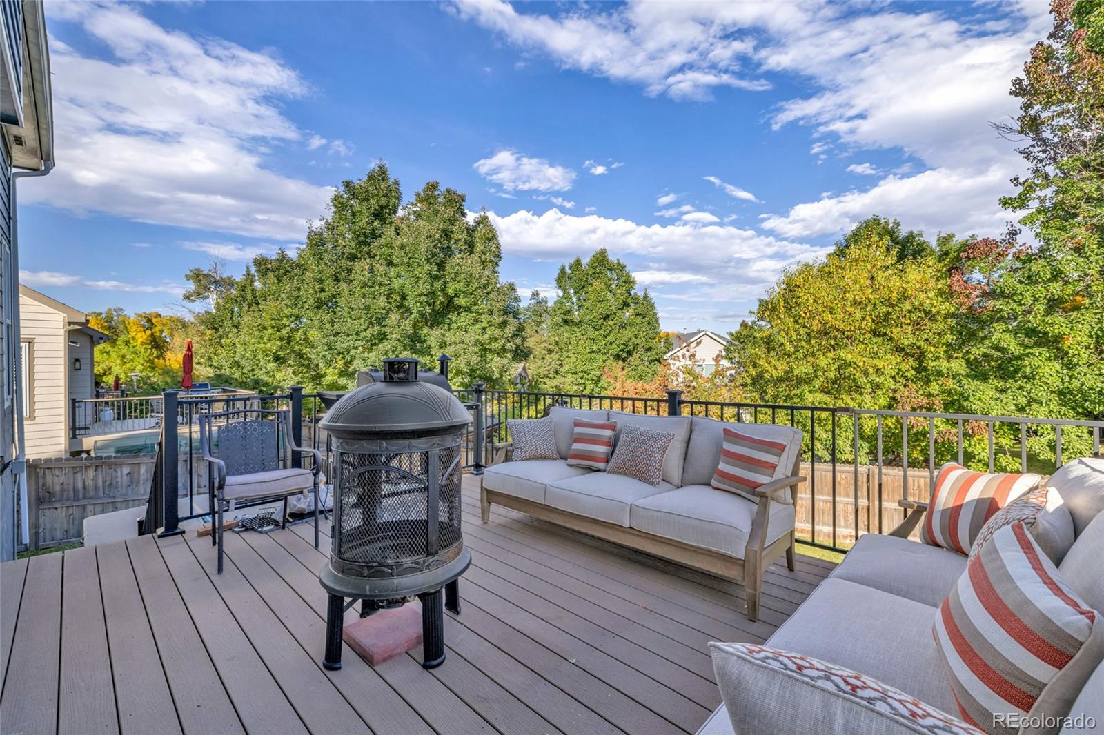 8204 Swadley Street Arvada, CO 80005 - Photo 34 of 39 a roof deck with table and chairs and wooden floor