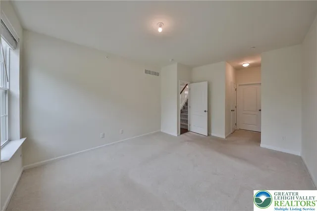 an empty room with a window and a ceiling fan