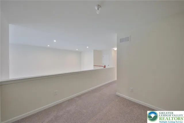 a view of an empty room and a kitchen