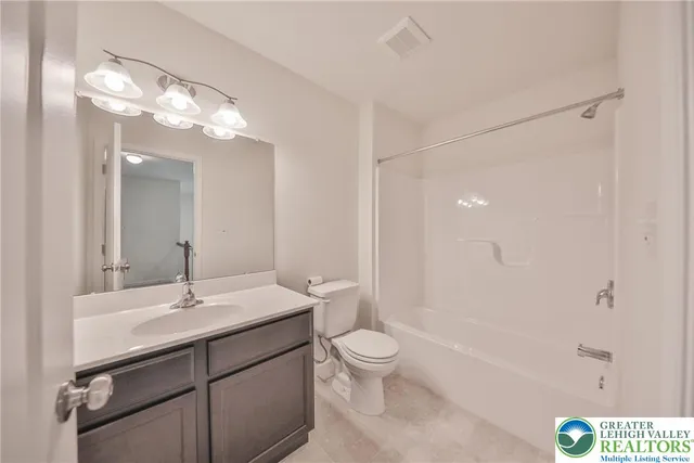 a bathroom with a sink a toilet a mirror and shower