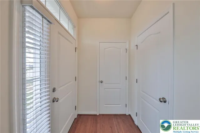 a view of a hallway with wooden floor and closet area