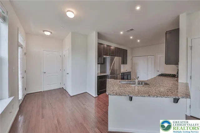 a kitchen with stainless steel appliances granite countertop a refrigerator and a sink