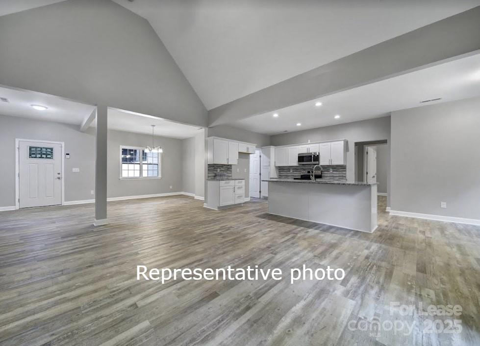 595 Foxwood Drive Southeast Concord, NC 28025 - Photo 2 of 8 a view of kitchen and empty room with wooden floor