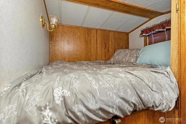 a bed sitting in a bedroom next to a window