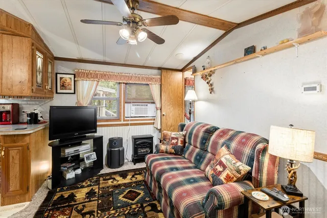 a living room with furniture a flat screen tv and a window