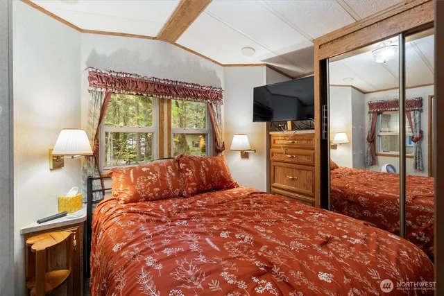 a bedroom with a bed and large mirror