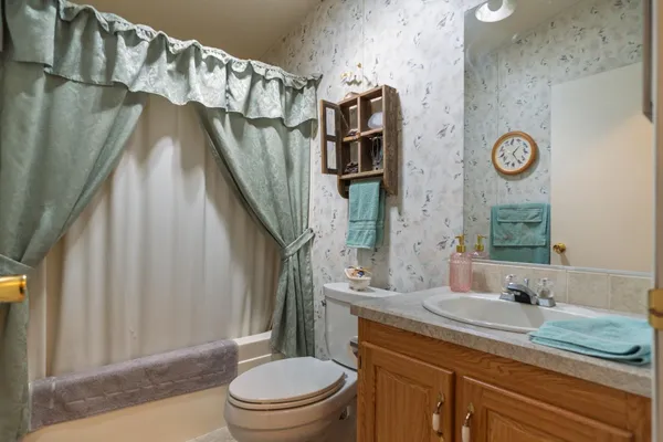 a bathroom with a granite countertop sink toilet and shower