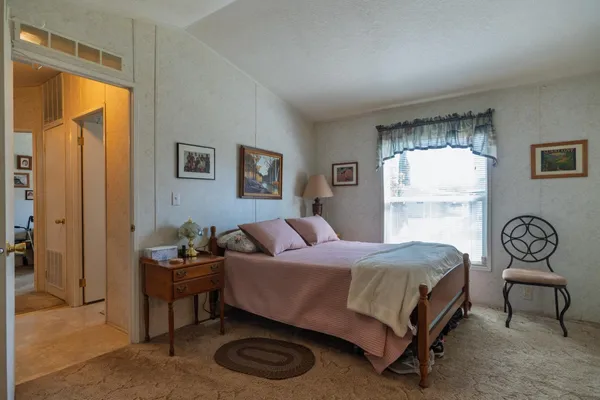 a bedroom with a bed dresser and a window
