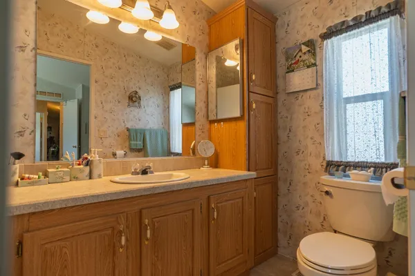 a bathroom with a granite countertop toilet sink and a mirror