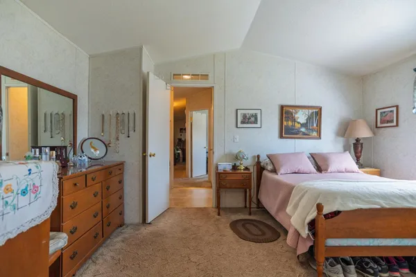a bedroom with a bed and a dresser in it