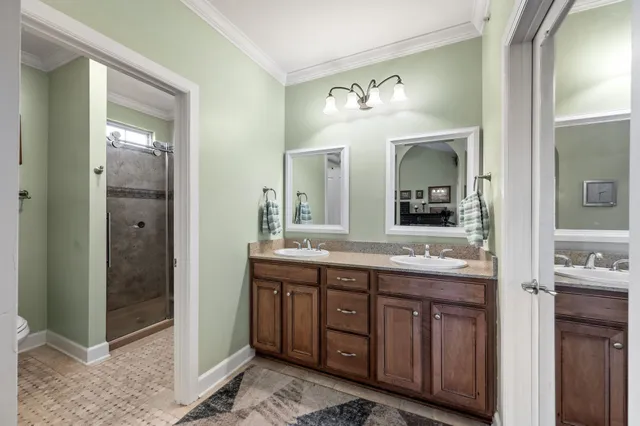 a bathroom with a granite countertop sink a toilet a mirror and shower