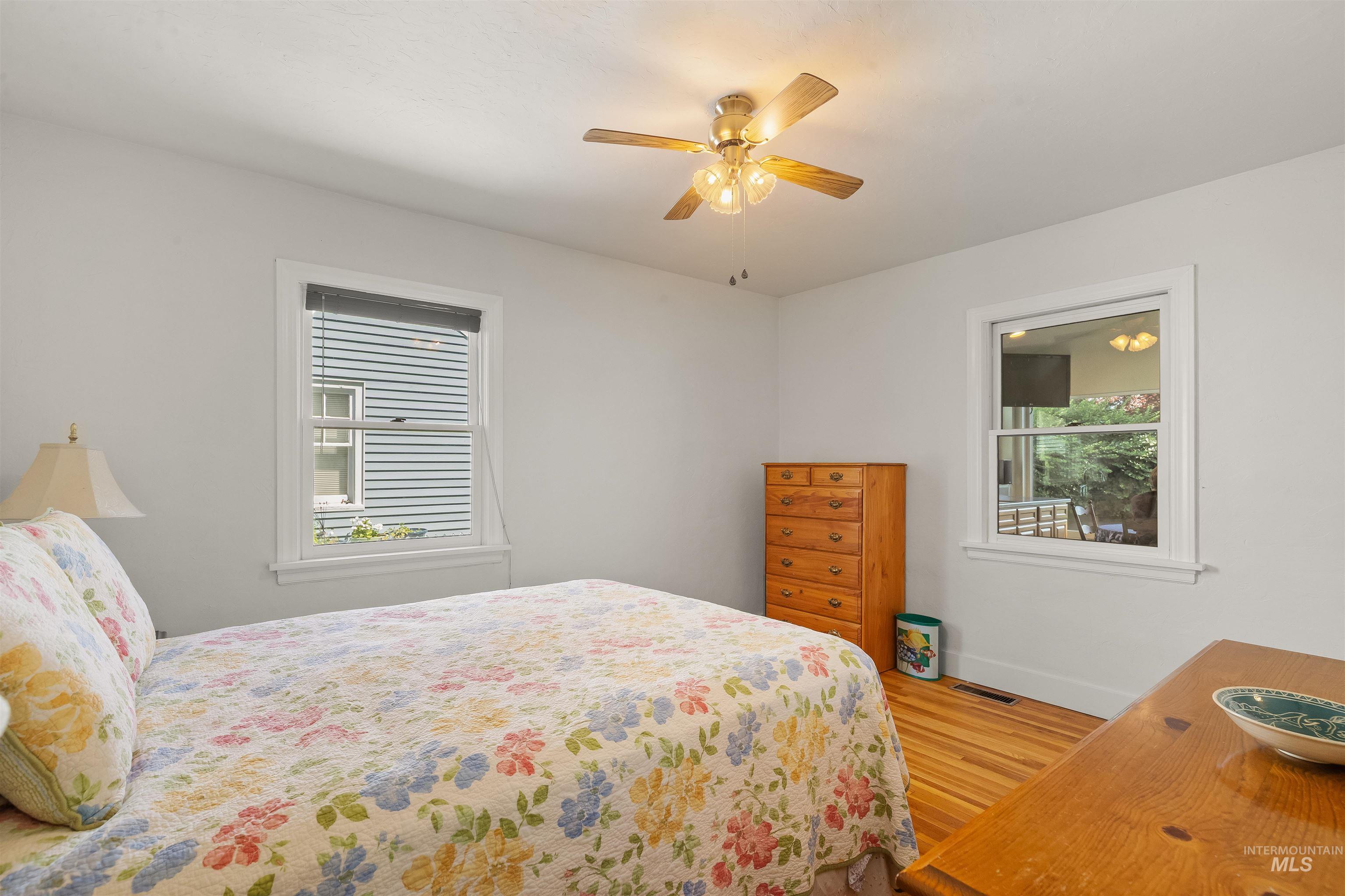 924 N Street Lewiston, ID 83501 - Photo 19 of 46 Bedroom featuring light-toned walls, hardwood flooring, a ceiling fan with integrated lighting, and two windows providing natural illumination