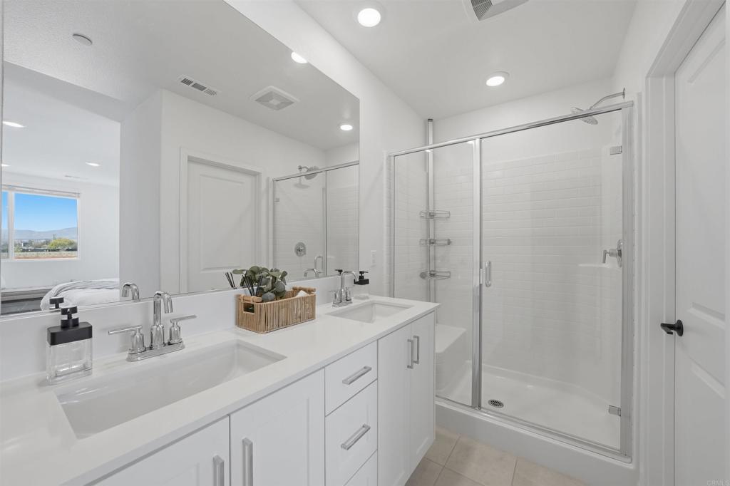 2402 Cascalote Loop San Diego, CA 92154 - Photo 28 of 35 a bathroom with double sink and a mirror