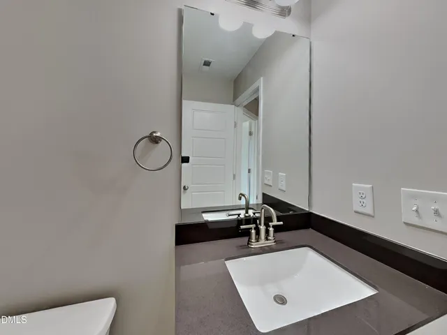 a bathroom with a sink a toilet and mirror