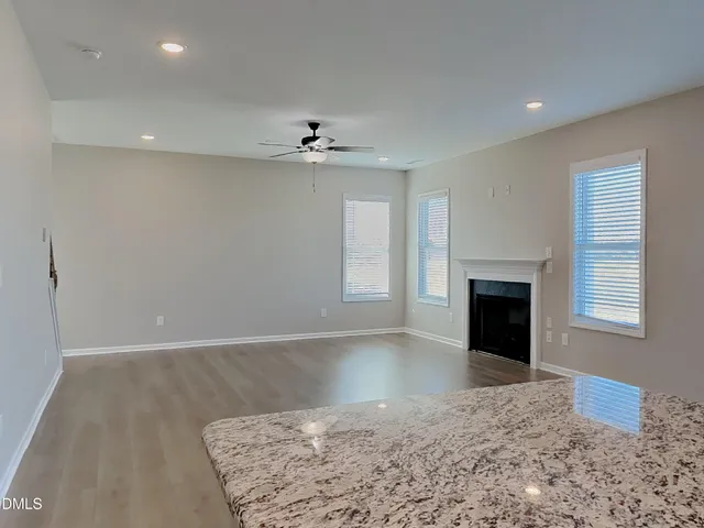 a view of an empty room with a fireplace and a window