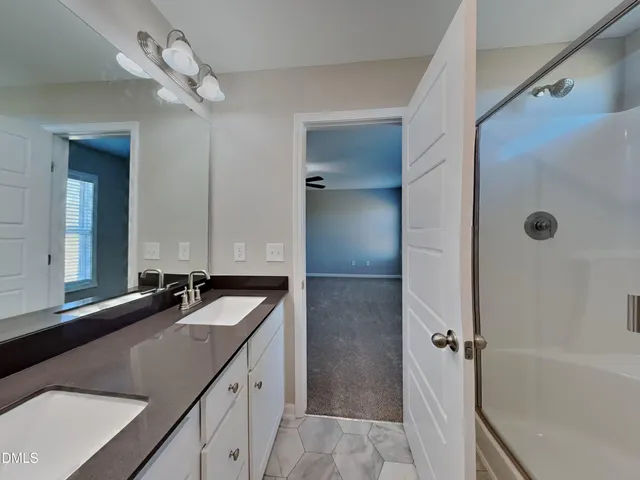 a bathroom with a granite countertop sink mirror and a bathtub