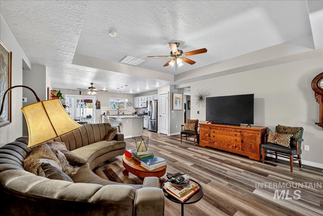 3174 North Greengate Way Star, ID 83669 - Photo 6 of 35 Living area with a raised ceiling, a textured ceiling, light wood finished floors, and a ceiling fan