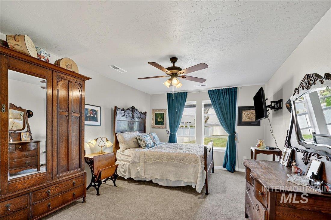 3174 North Greengate Way Star, ID 83669 - Photo 10 of 35 Bedroom with light colored carpet, a textured ceiling, and a ceiling fan