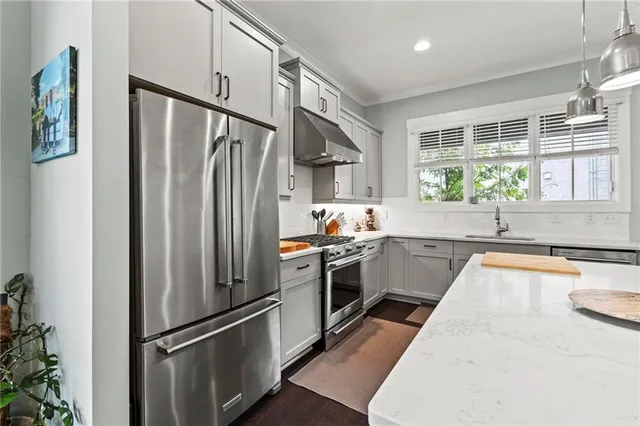 a kitchen with stainless steel appliances granite countertop a refrigerator and a sink