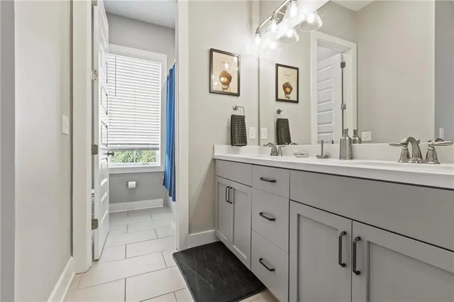 a spacious bathroom with a double vanity sink a mirror and a