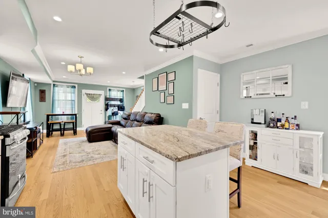 a living room with stainless steel appliances granite countertop furniture and wooden floor