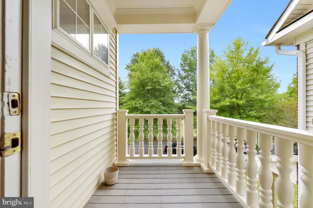 a view of empty room with wooden floor and kitchen view