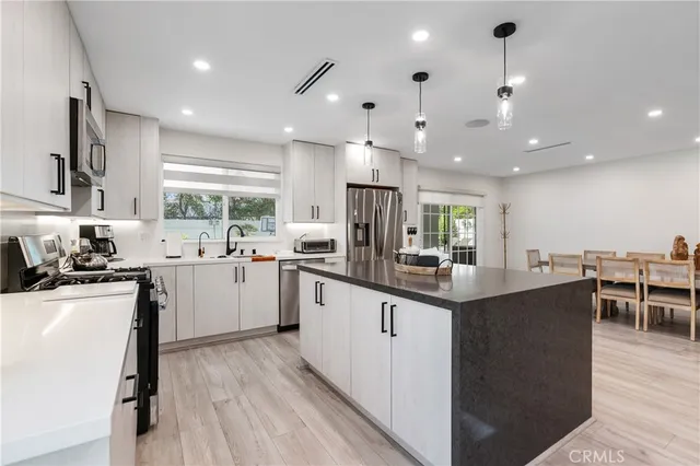 a kitchen with stainless steel appliances granite countertop sink stove top oven and cabinets