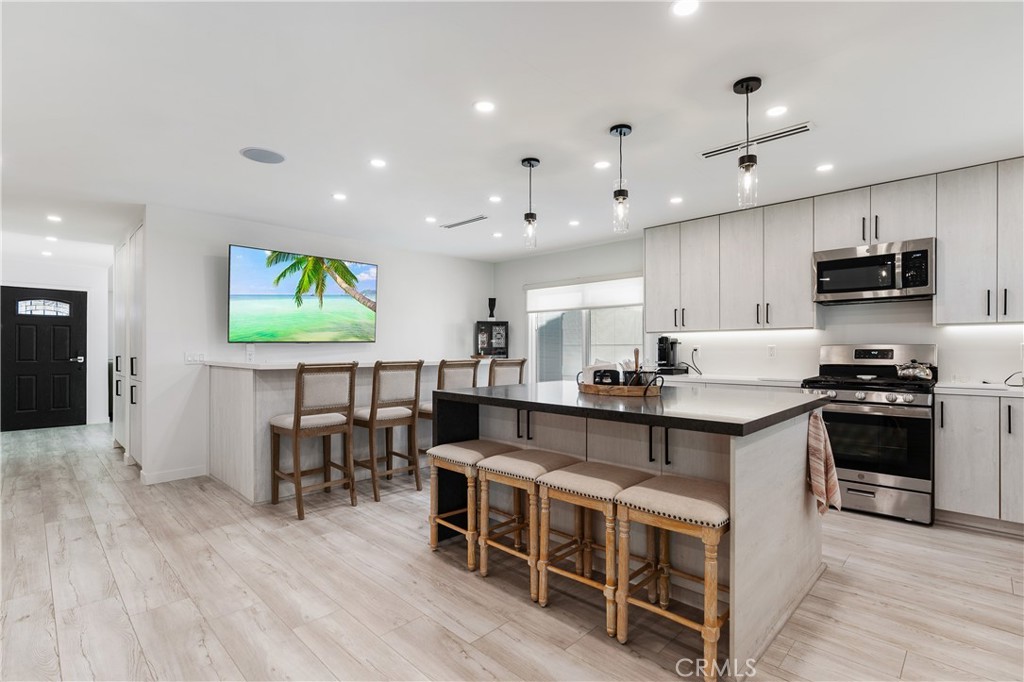68920 Concepcion Road Cathedral City, CA 92234 - Photo 13 of 35 a open kitchen with stainless steel appliances granite countertop a stove top oven a sink a dining table and chairs with wooden floor