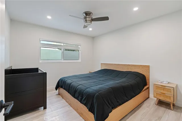 a bedroom with a bed and wooden floor