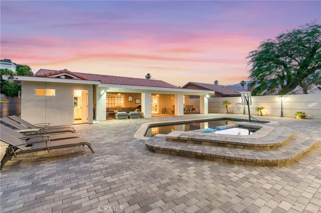 a view of a house with swimming pool and sitting area