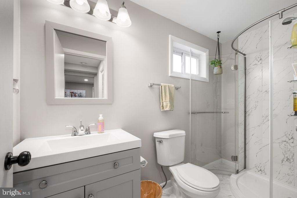 3018 Kramer Street Silver Spring, MD 20902 - Photo 29 of 38 a bathroom with a sink a mirror a toilet and shower
