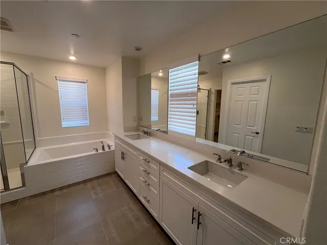 a bathroom with a granite countertop sink mirror and a bathtub
