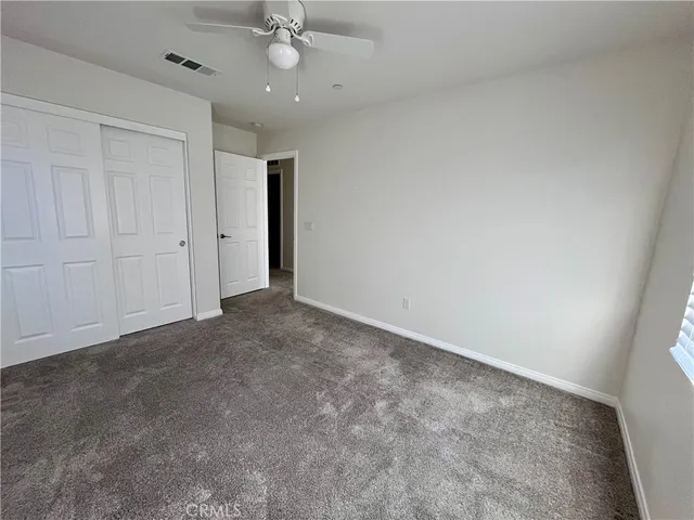 an empty room with a empty space and a ceiling fan