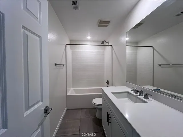 a bathroom with a double vanity sink toilet mirror and bathtub