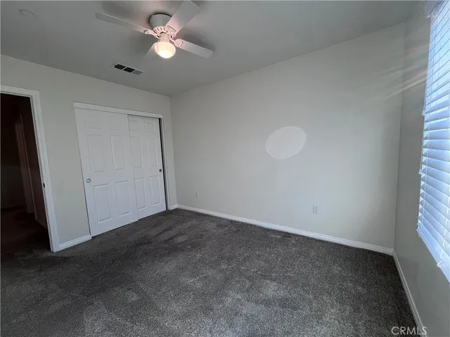 an empty room with closet and a window