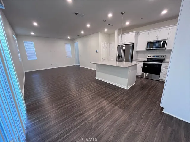a view of kitchen with microwave refrigerator and cabinets