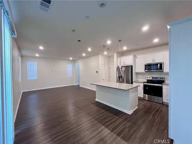 a kitchen with stainless steel appliances kitchen island granite countertop a stove top oven a sink and a microwave