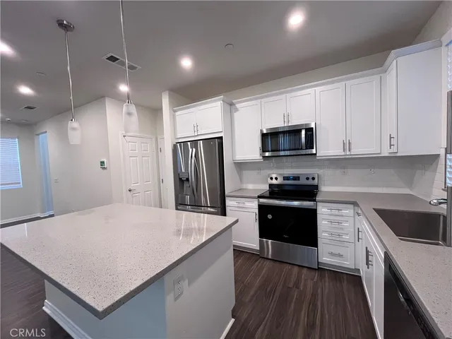 a kitchen with refrigerator cabinets and wooden floor