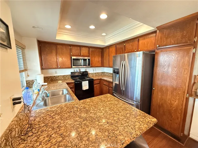 a kitchen with stainless steel appliances granite countertop a refrigerator sink and microwave
