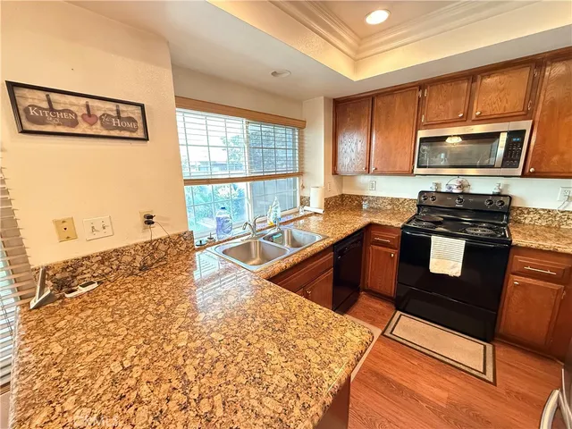 a kitchen with stainless steel appliances granite countertop a stove a sink and a microwave