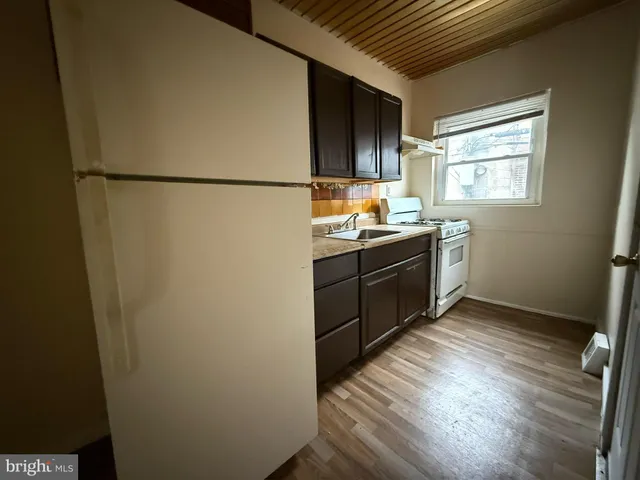 a kitchen with sink cabinets and wooden floor