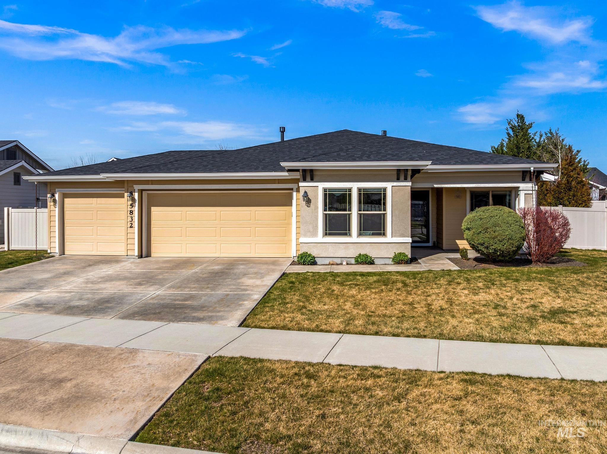 Ranch-style house featuring an attached garage, driveway, and roof with shingles