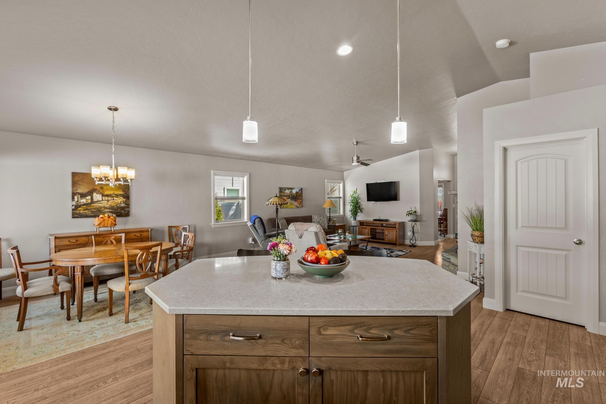 5832 West Rotherham Drive Eagle, ID 83616 - Photo 42 of 42 Kitchen with lofted ceiling, open floor plan, light wood-style floors, a kitchen island, and light stone countertops