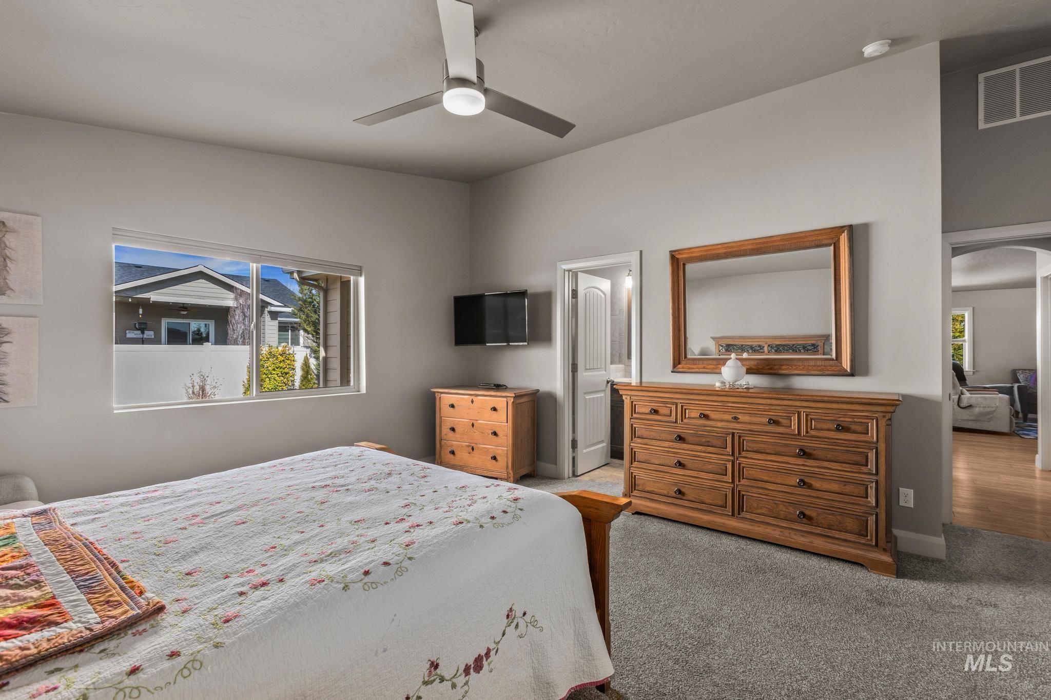 5832 West Rotherham Drive Eagle, ID 83616 - Photo 17 of 42 Bedroom with arched walkways, light carpet, and a ceiling fan