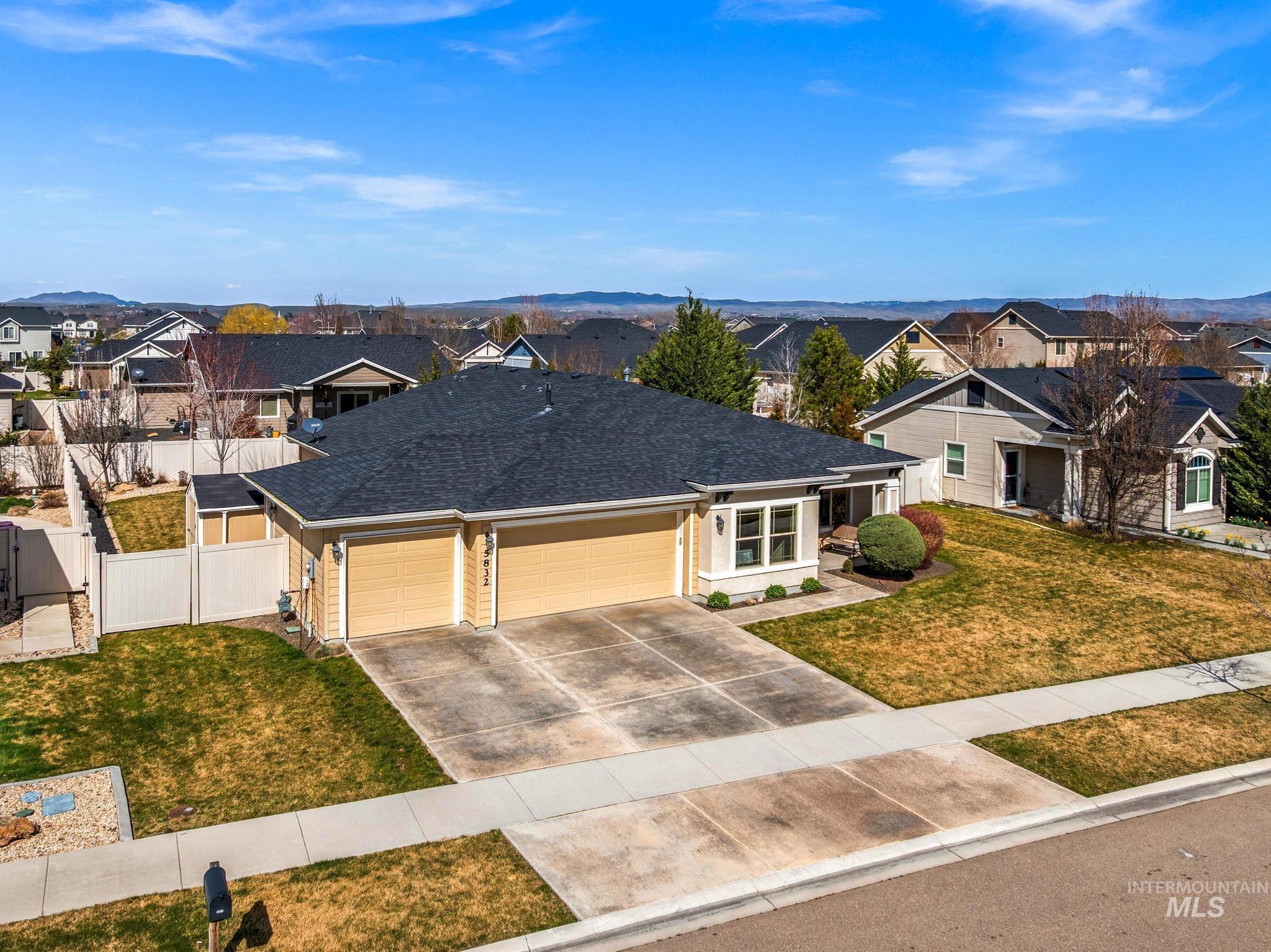 5832 West Rotherham Drive Eagle, ID 83616 - Photo 2 of 42 View of front of property featuring an attached garage, a residential view, concrete driveway, roof with shingles, and a mountain view