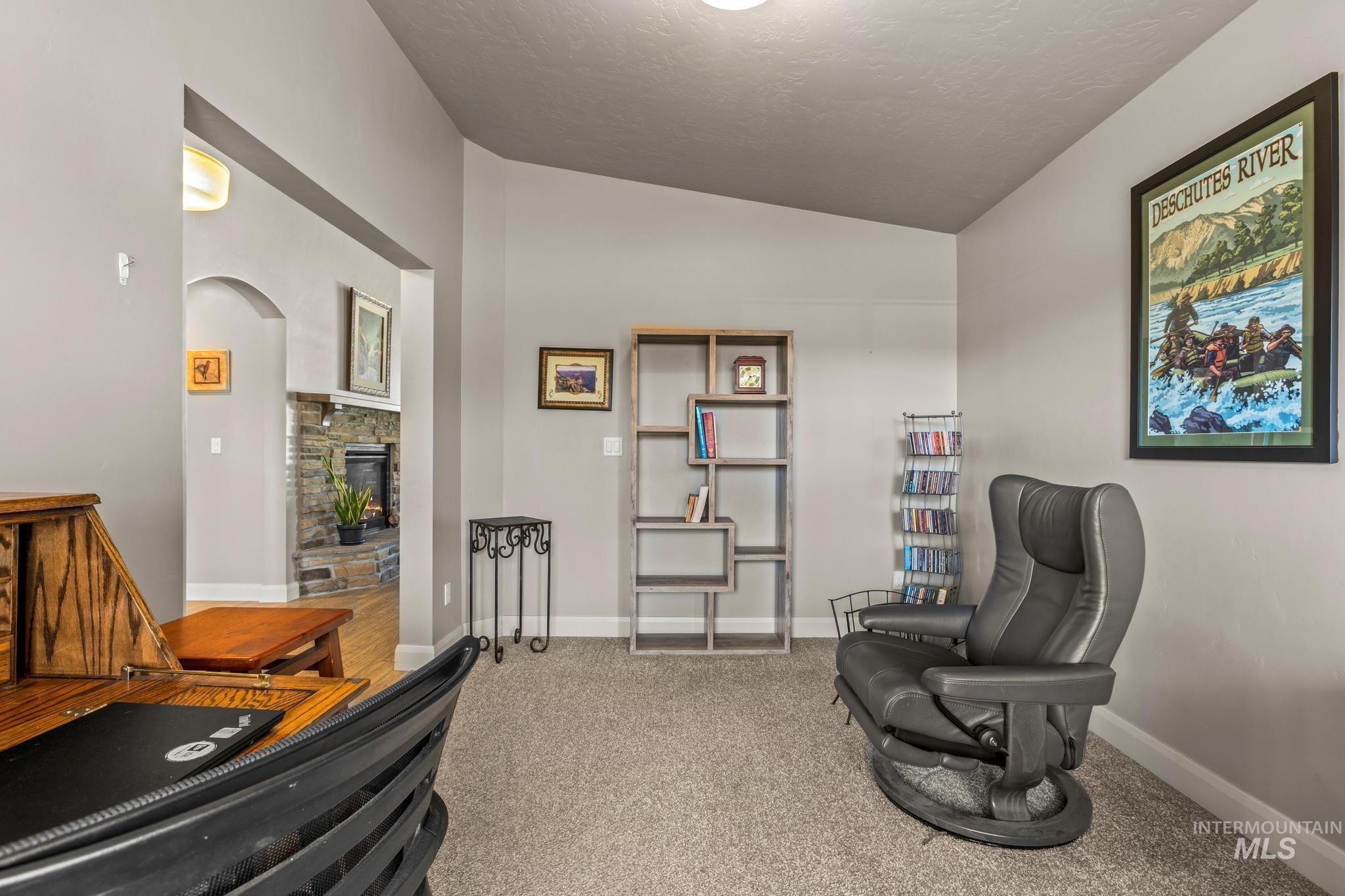 5832 West Rotherham Drive Eagle, ID 83616 - Photo 30 of 42 Sitting room featuring light colored carpet, vaulted ceiling, a fireplace, and arched walkways