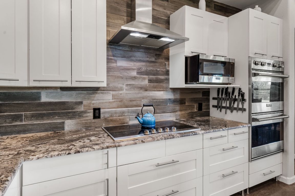 4204 Arthur Circle Leander, TX 78641 - Photo 16 of 40 a kitchen with stainless steel appliances granite countertop a stove and white cabinets
